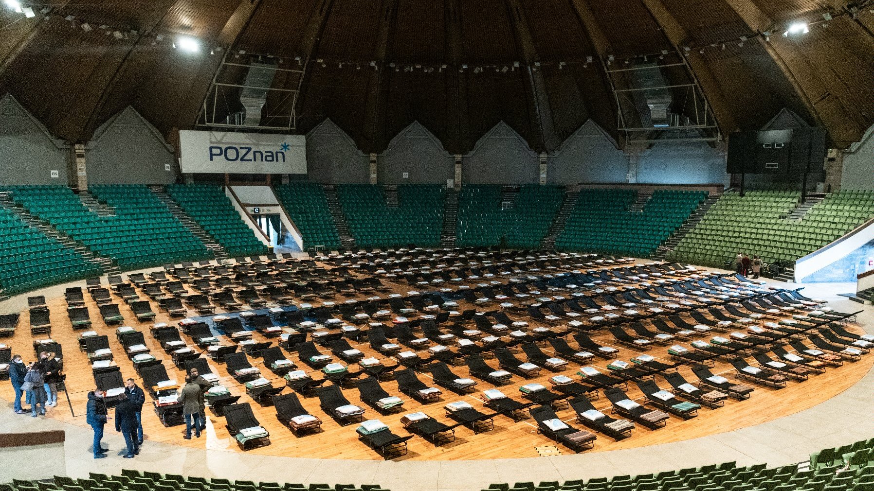 Wnętrze hali Arena. Na środki obiektu widać setki łóżek polowych.