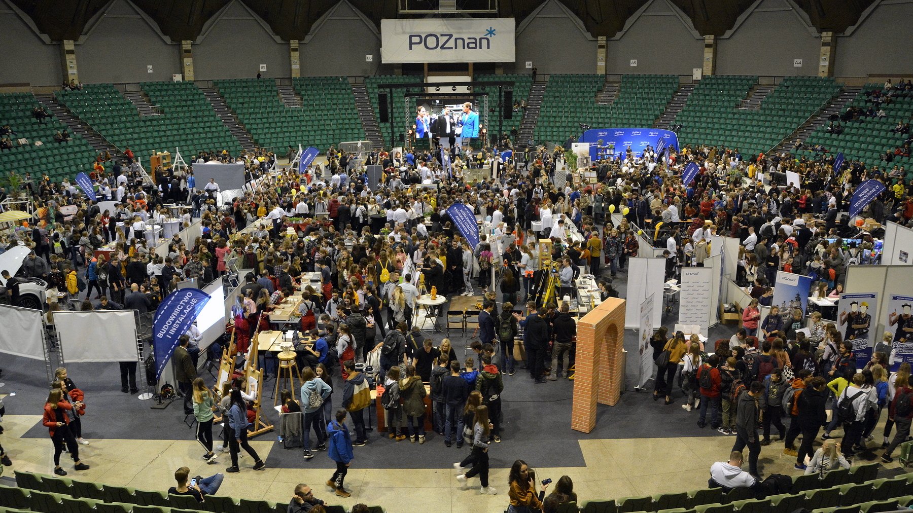 Zdjęcie przedstawia tłum ludzi we wnętrzu hali Arena. - grafika rozmowy