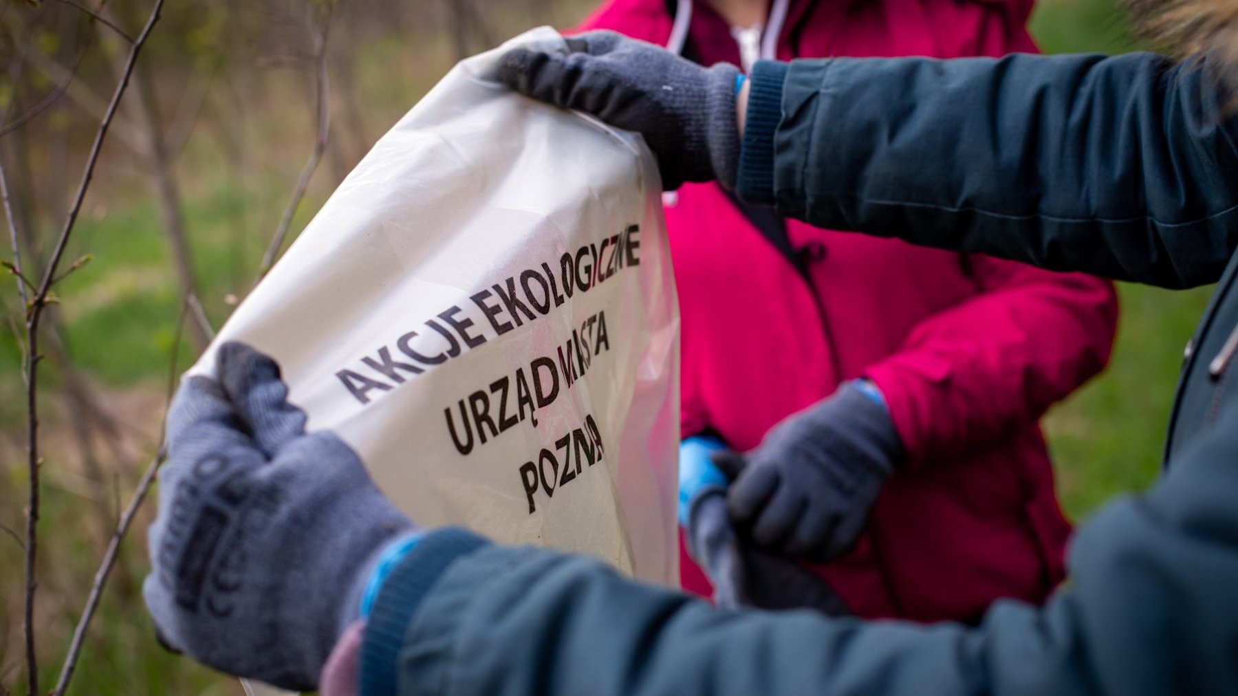 Zdjęcie przedstawia ręce jakiejś osoby trzymającej worek na śmieci.