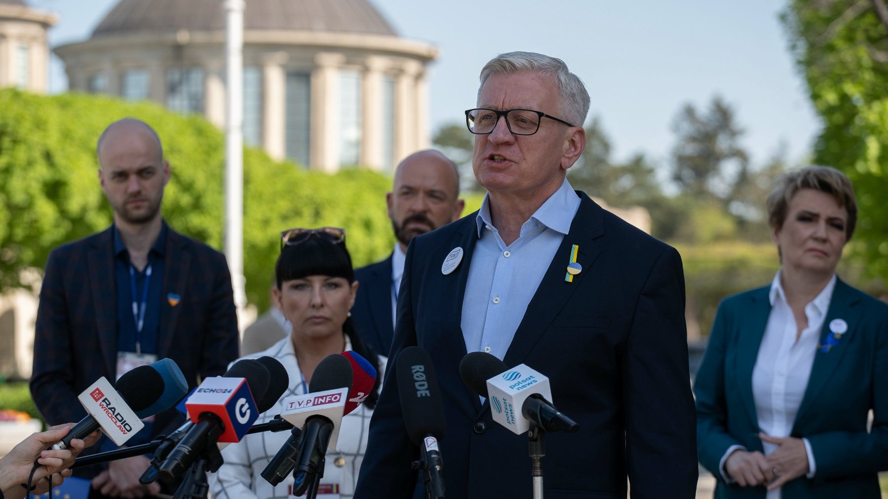 Zdjęcie przedstawia prezydenta Poznania przy mikrofonie podczas konferencji prasowej.