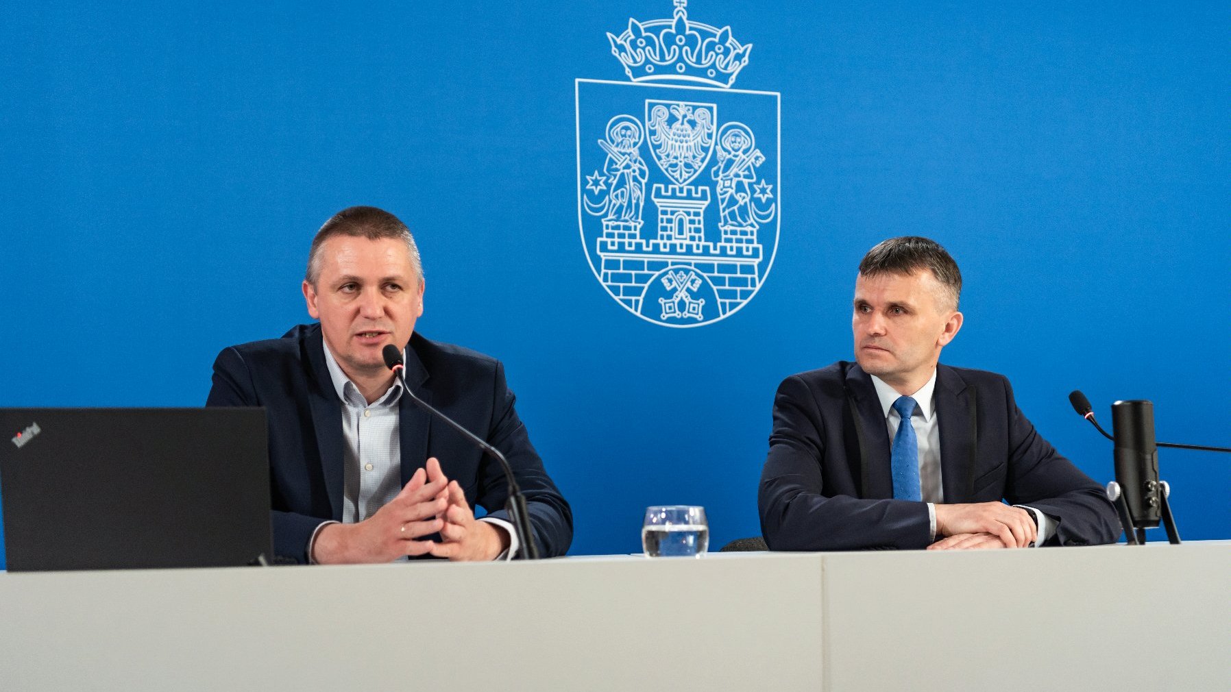 Galeria zdjęć przedstawia Patryka Pawełczaka i Mariusza Szlendaka za stołem podczas konferencji prasowej.