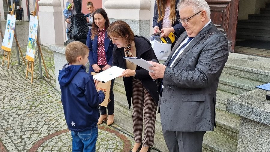 Galeria zdjęć przedstawia piknik na dziedzińcu urzędu miasta, w tym wręczenie nagród dzieciom, biorącym udział w konkursie.