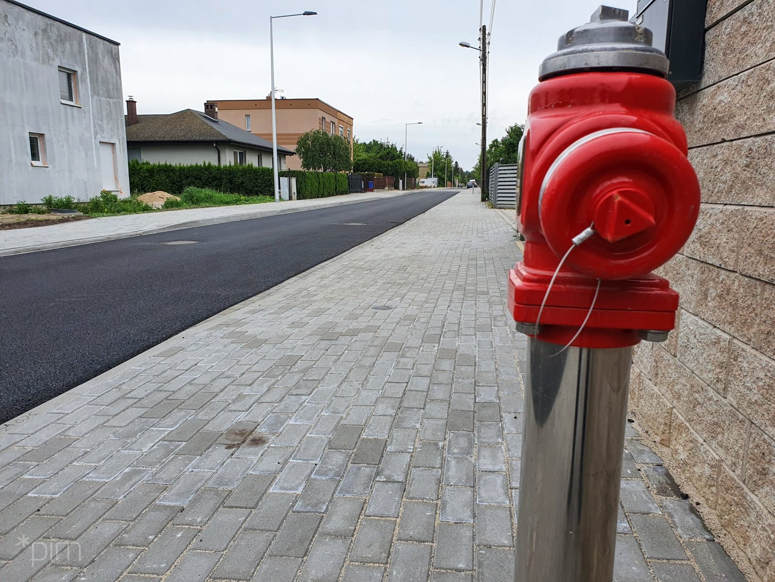 Na zdjęciu ulica z nowo położonym chodnikiem i nową nawierzchnią, na pierwszym planie czerwony hydrant - grafika rozmowy