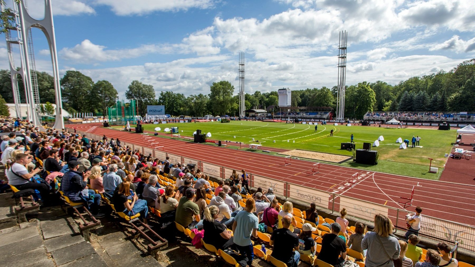 Zdjęcie przedstawia zdjęcie stadionu i ludzi na trybunach.