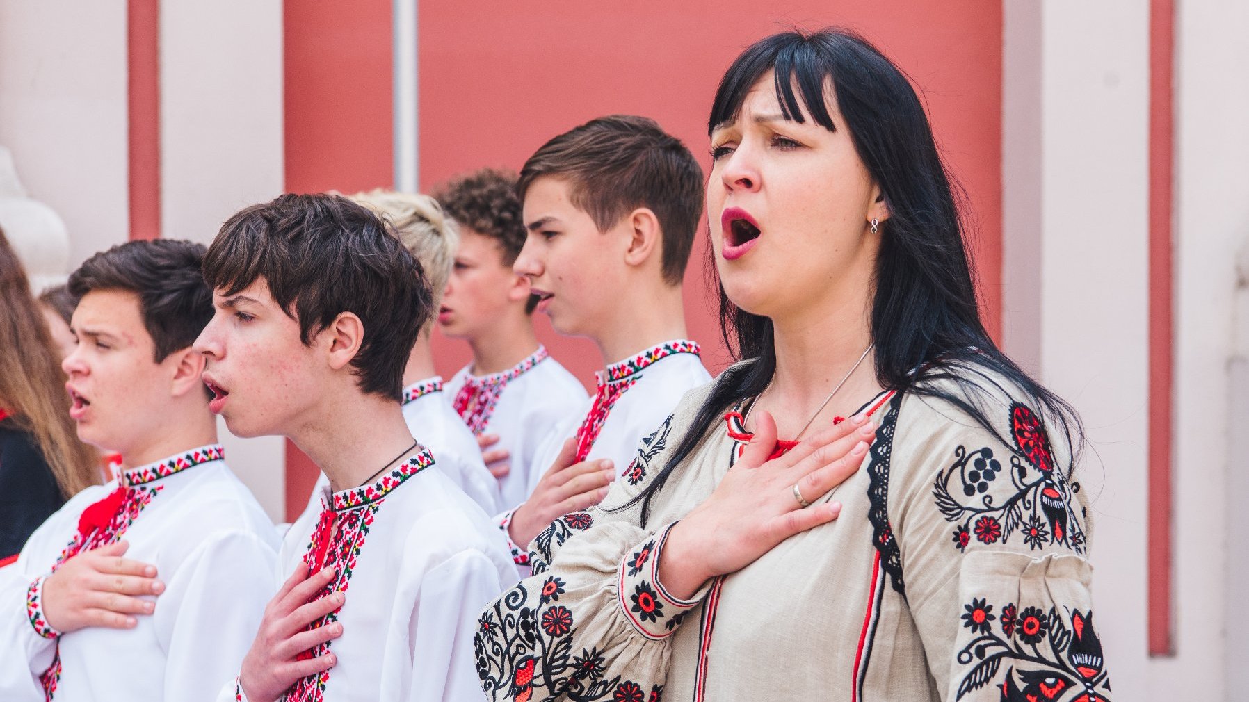 Na zdjęciu zbliżenie na twarze śpiewających chórzystów