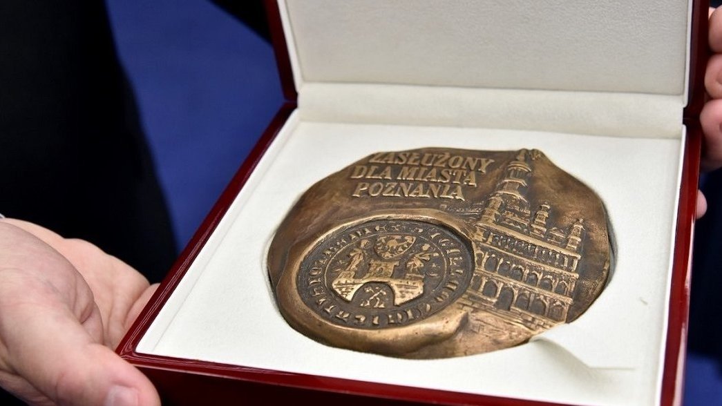 Na zdjęciu medal "Zasłużony dla Miasta Poznania" w pudełku, trzymany w dłoniach