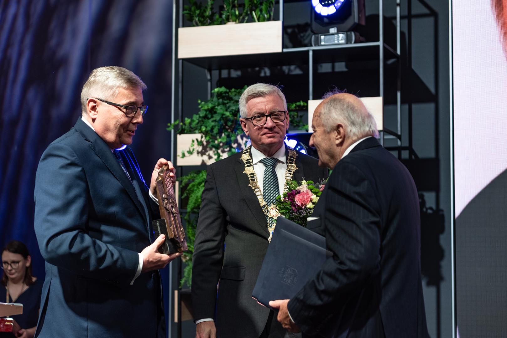 Na zdjęciu prezydent miasta i przewodniczący rady miasta wręczają statuetkę Honorowego Obywatela Poznania prof. Łączkowskiemu - grafika rozmowy