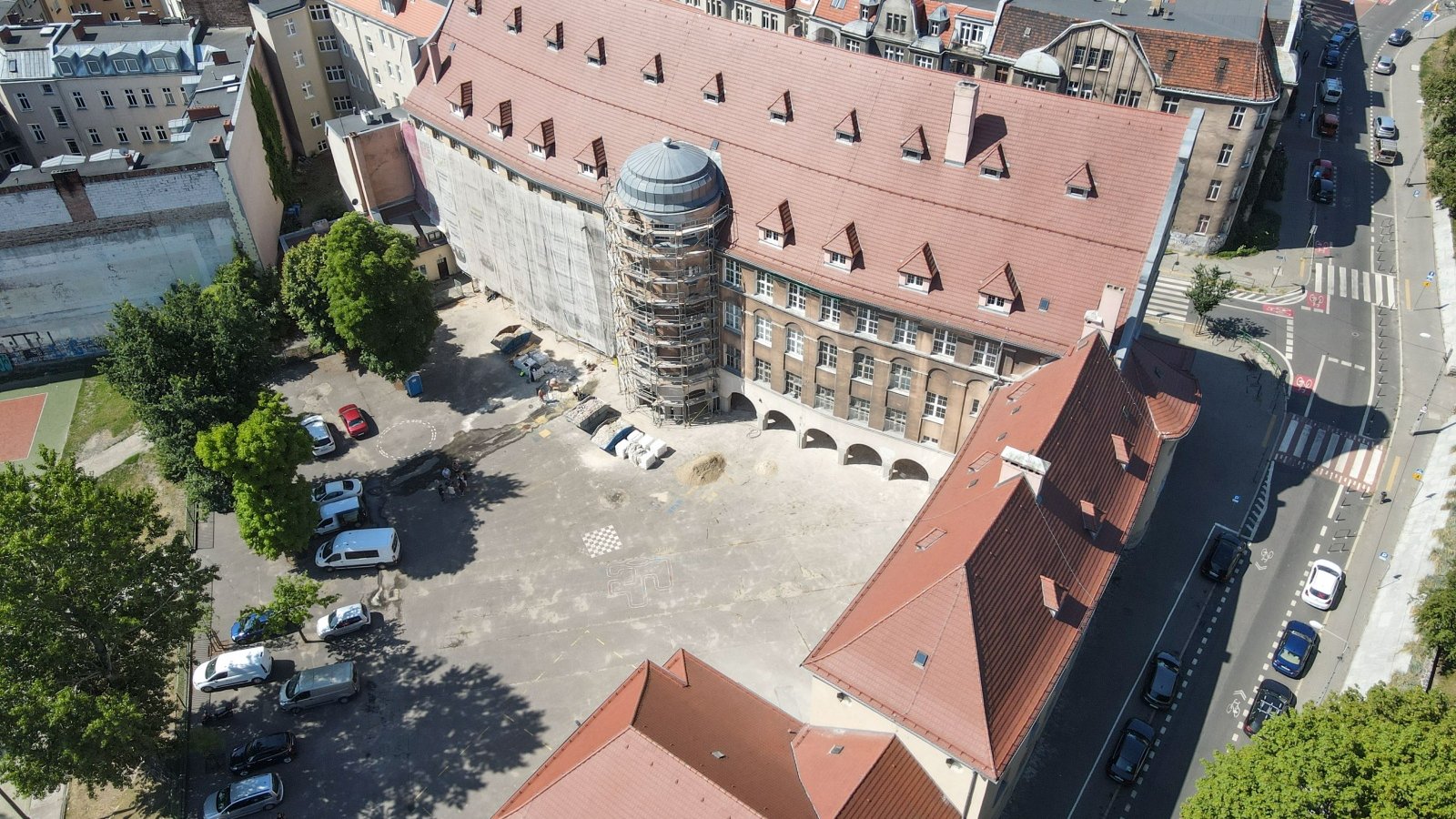 Zdjęcie pokazuje dziedziniec szkoły przy ul. Różanej. Po lewej stronie od wieżyczki stoją rusztowania