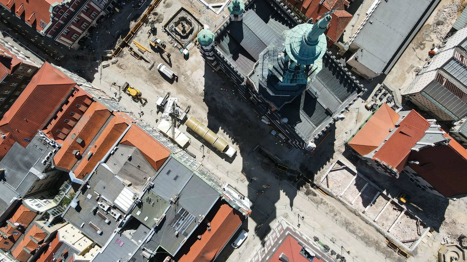 Zdjęcie przedstawia widok na Stary Rynek w Poznaniu z lotu ptaka. Na fotografii widoczen są dachy kamienic i sprzęt budowlany.