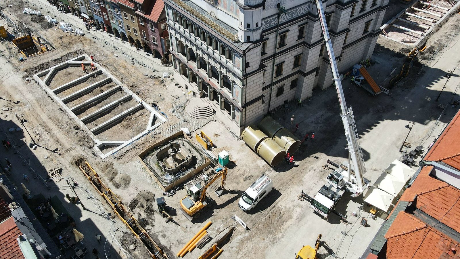 Zdjęcie przedstawia widok na Stary Rynek w Poznaniu z lotu ptaka. Na fotografii widoczen są dachy kamienic i sprzęt budowlany.