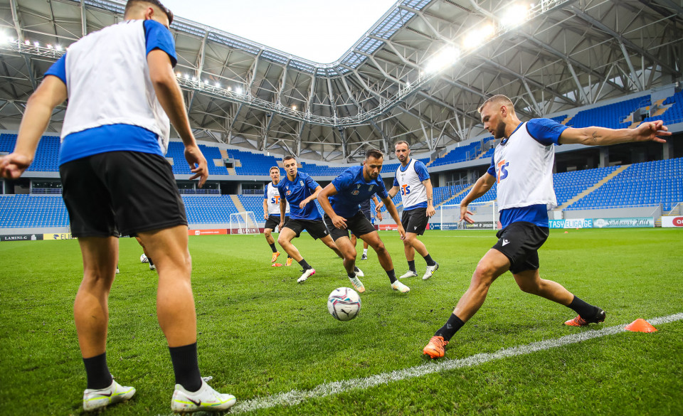 Grupa piłkarzy podaje piłkę miedzysobą. W tle stadion. - grafika rozmowy