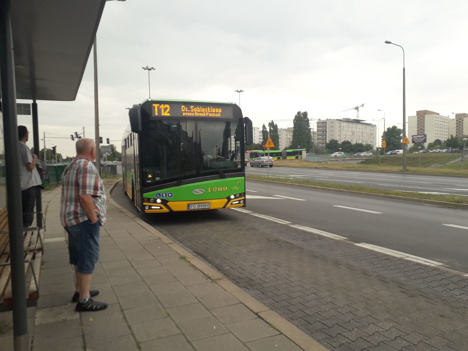 Na zdjęciu autobus linii T12 podjeżdżający na przystanek - grafika rozmowy