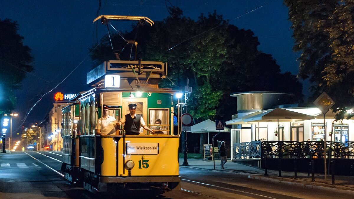 Na zdjęciu zabytkowy tramwaj po zmierzchu, oświetlony lampami