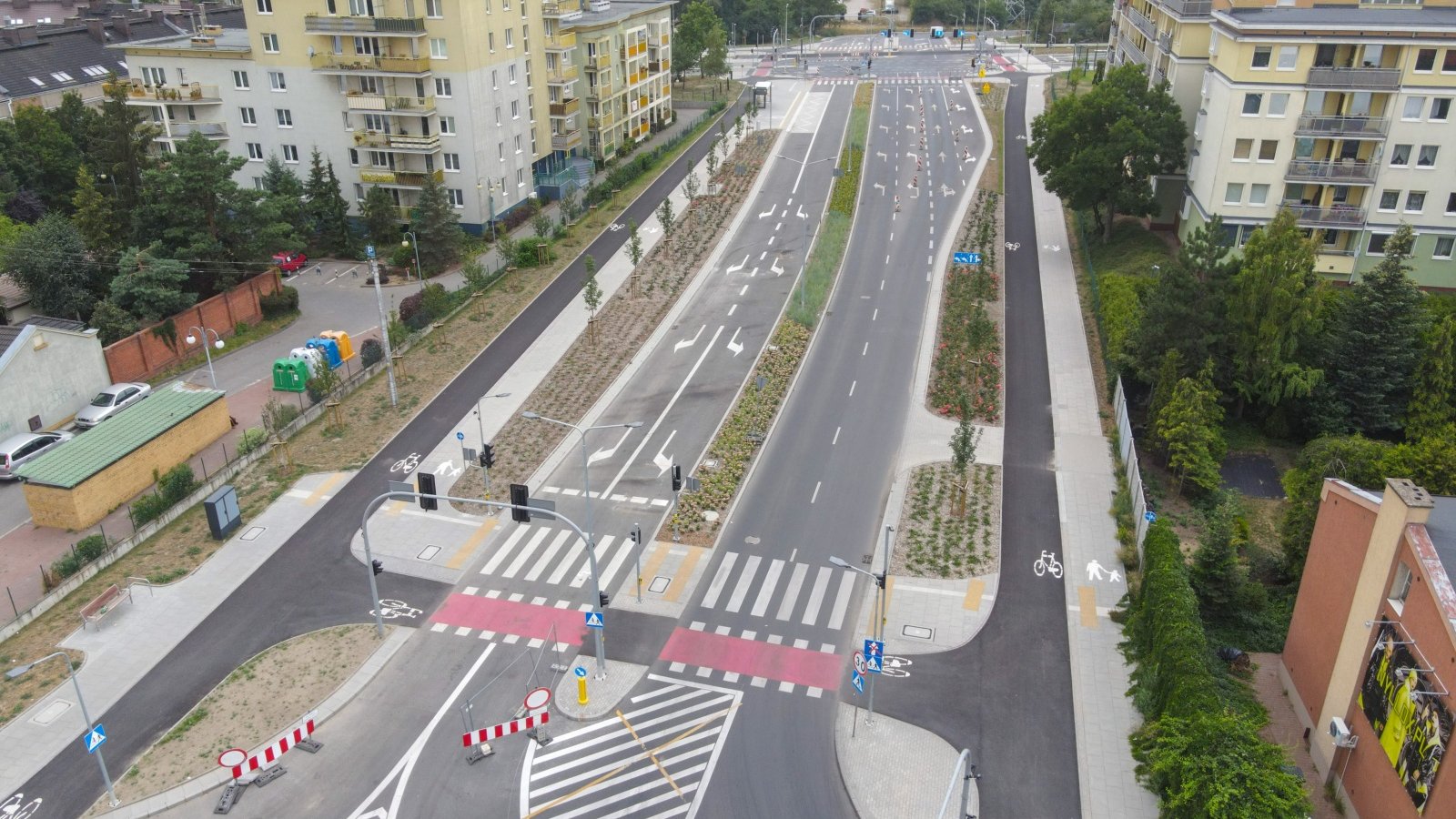 Na zdjęciu dwujezdniowa ulica widziana z lotu ptaka, z boku widać bloki