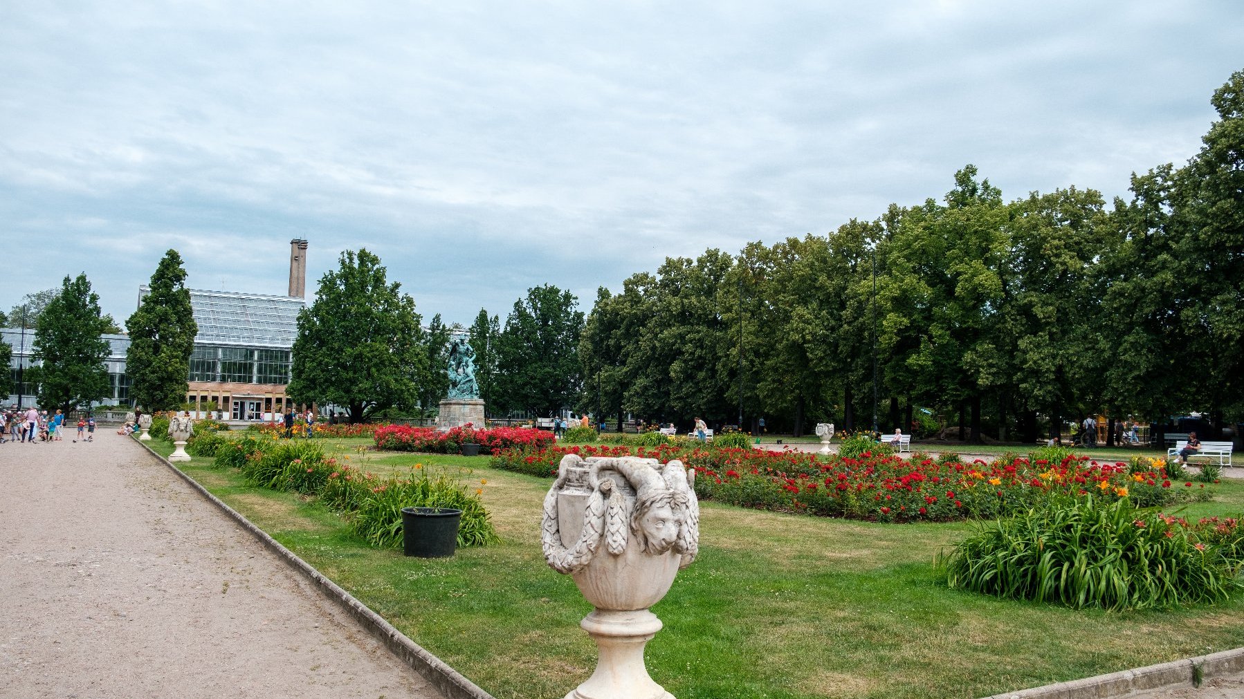 Park Wilsona. Na pierwszym planie zieleń i ścieżka, w tle bydynek palmiarni.