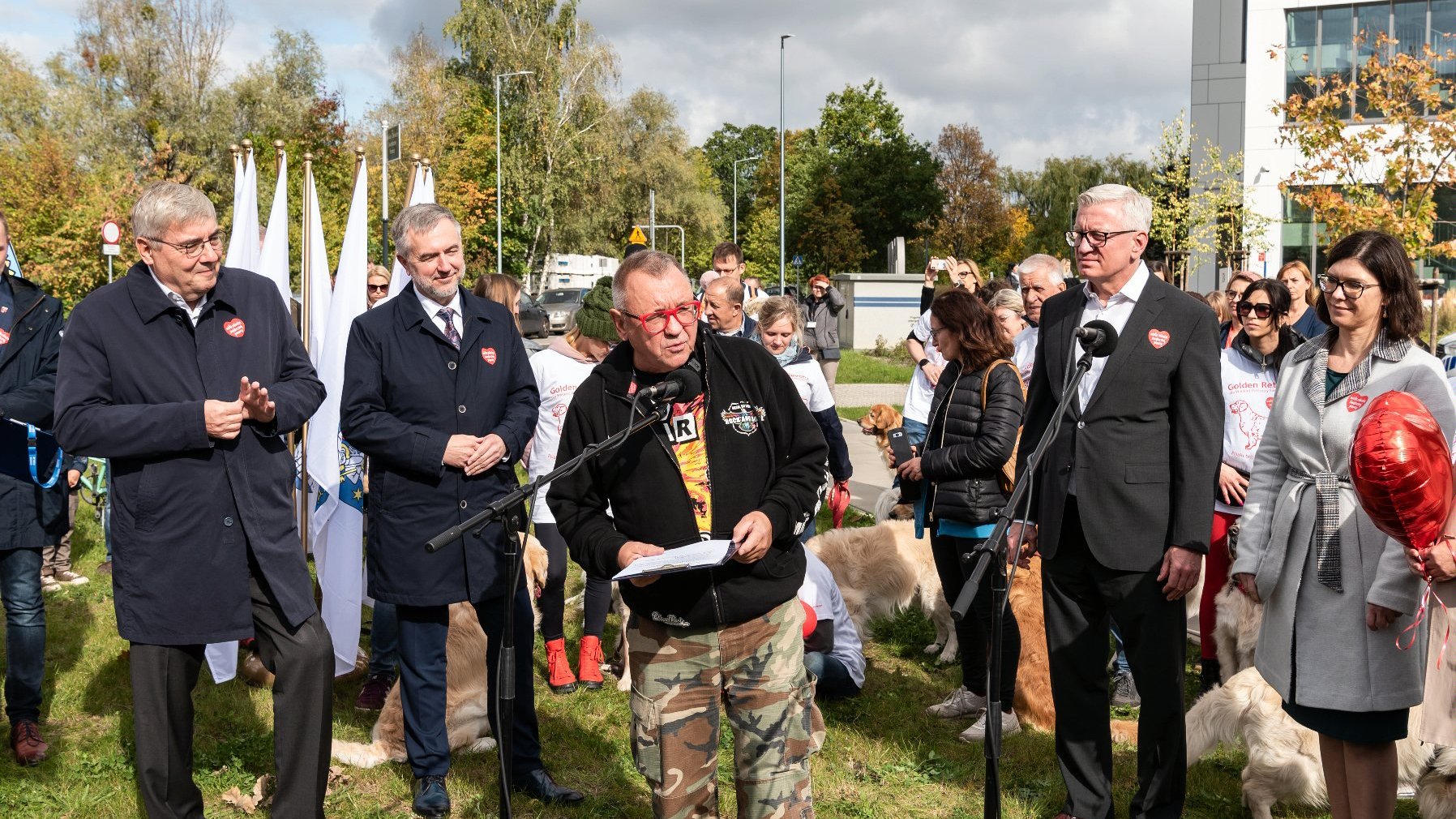 Na zdjęciu Jurek Owsiak przy mikrofonie, wokół samorządowcy i wolontariusze z psami