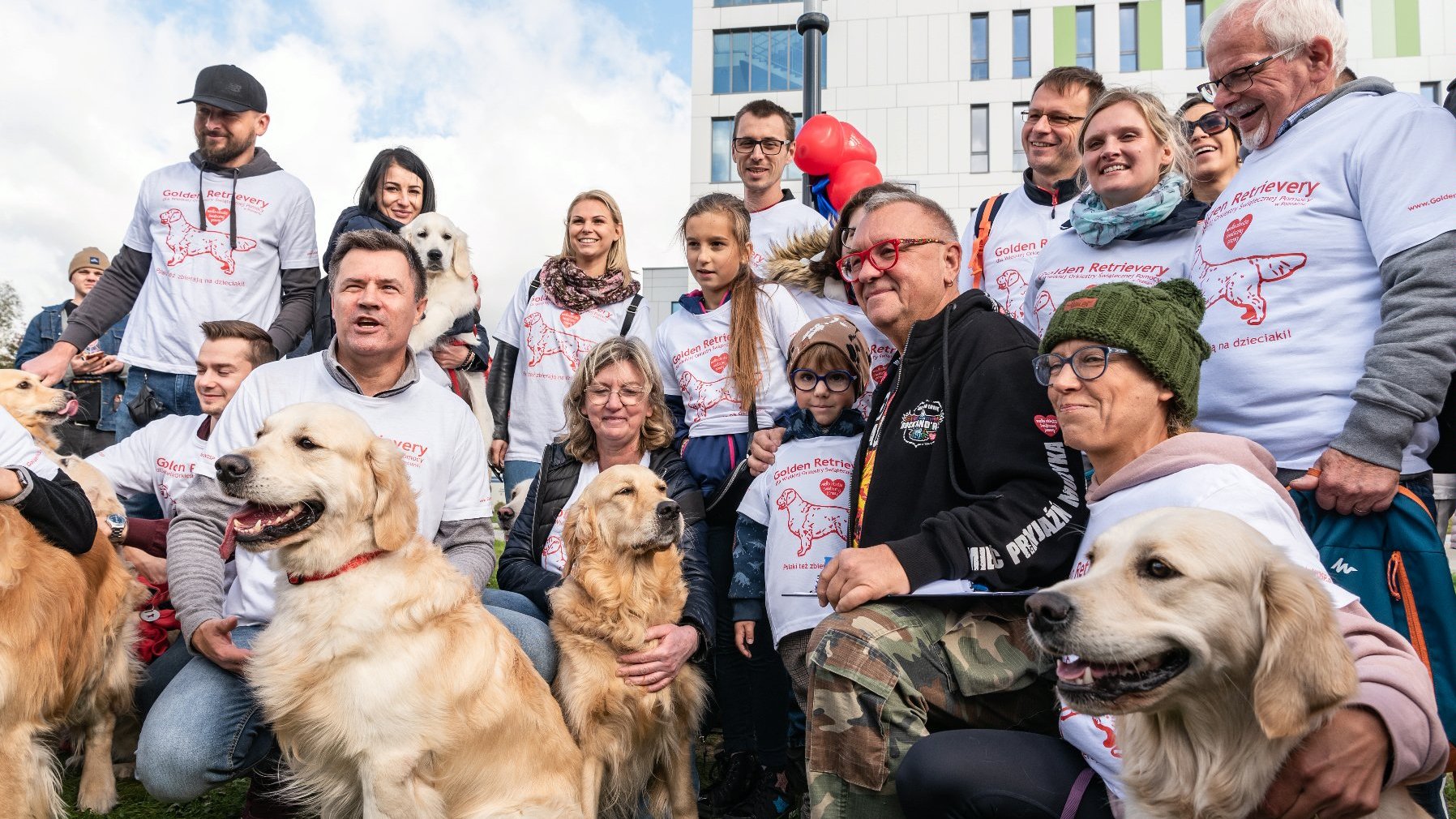 Na zdjęciu Jurek Owsiak w towarzystwie wolontariuszy i ich golden retrieverów