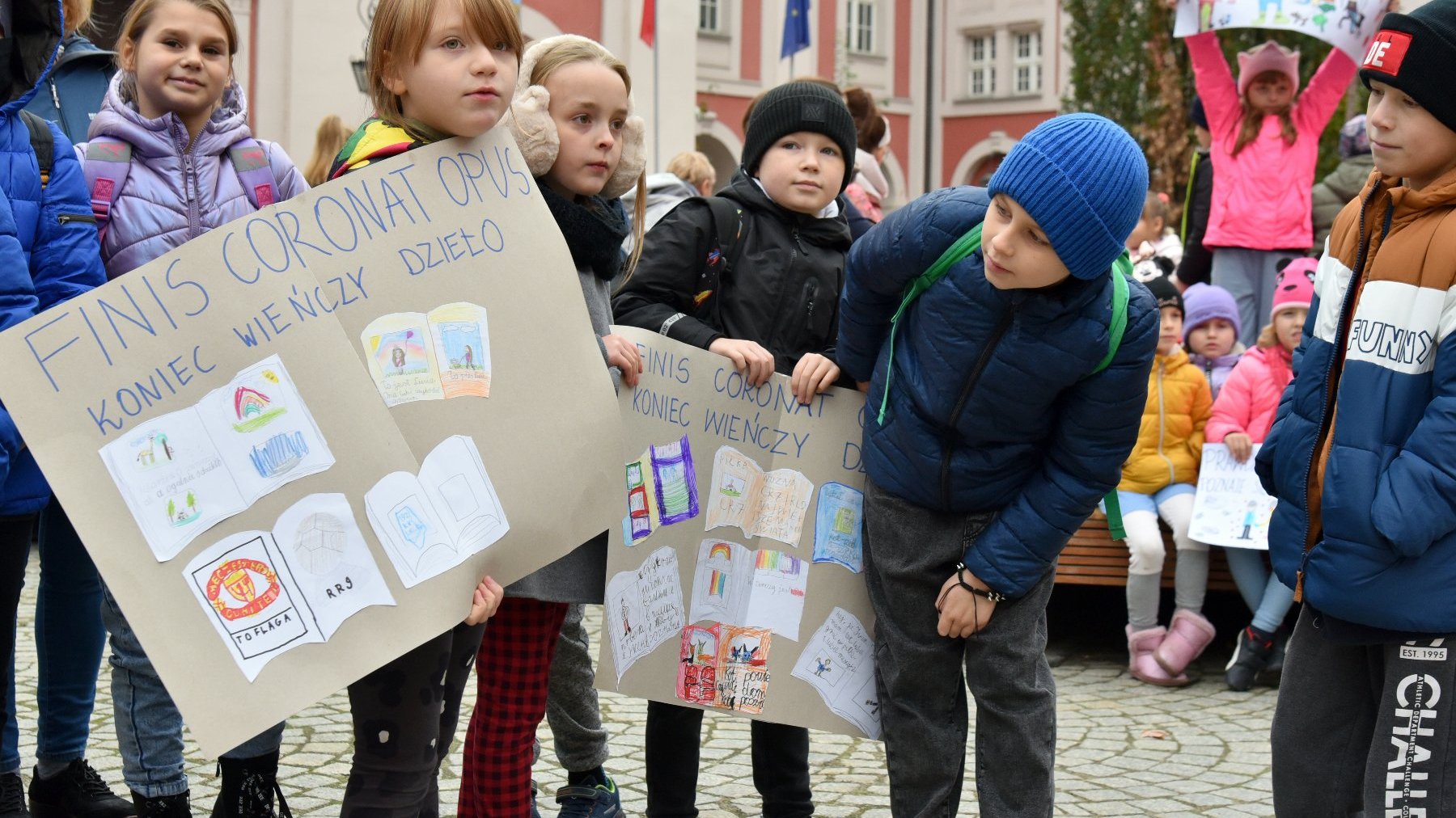 Na zdjęciu dzieci przyglądające się zrobionym przez siebie plakatom