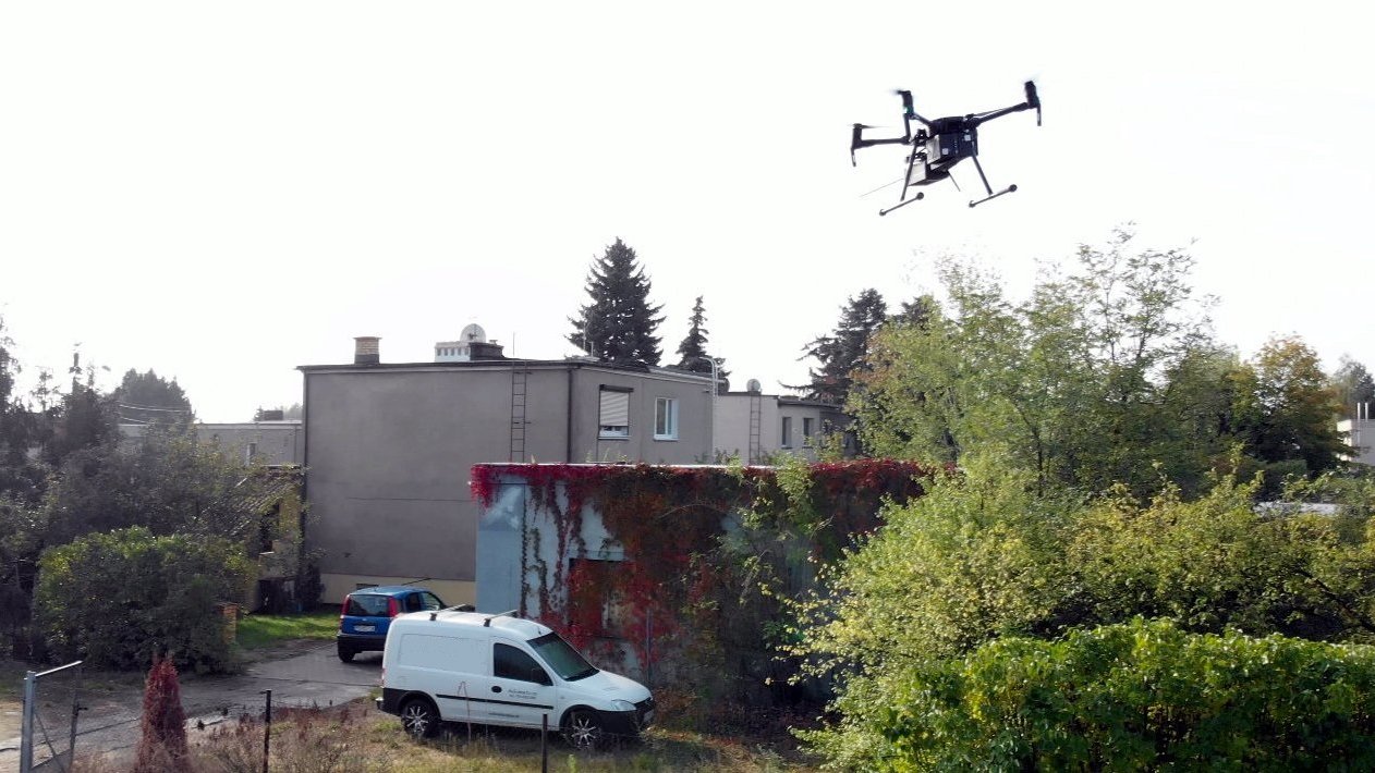 Na zdjęciu budynki jednorodzinne, nad nimi na pierwszym planie dron