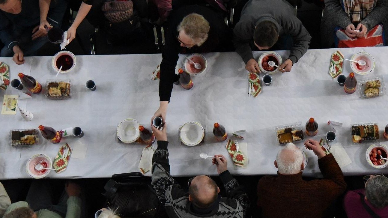 Na zdjęciu widok z góry na stół oraz siedzących przy nim ludzi