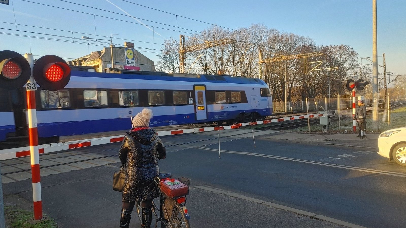 Samochody stojące przed zamkniętym przejazdem kolejowym przy ul. Starołęckiej