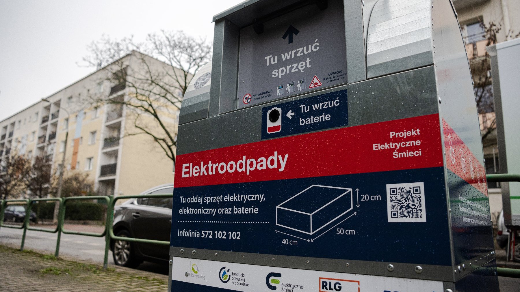 Na zdjęciu pojemnik na elektroodpady, w tle bloki