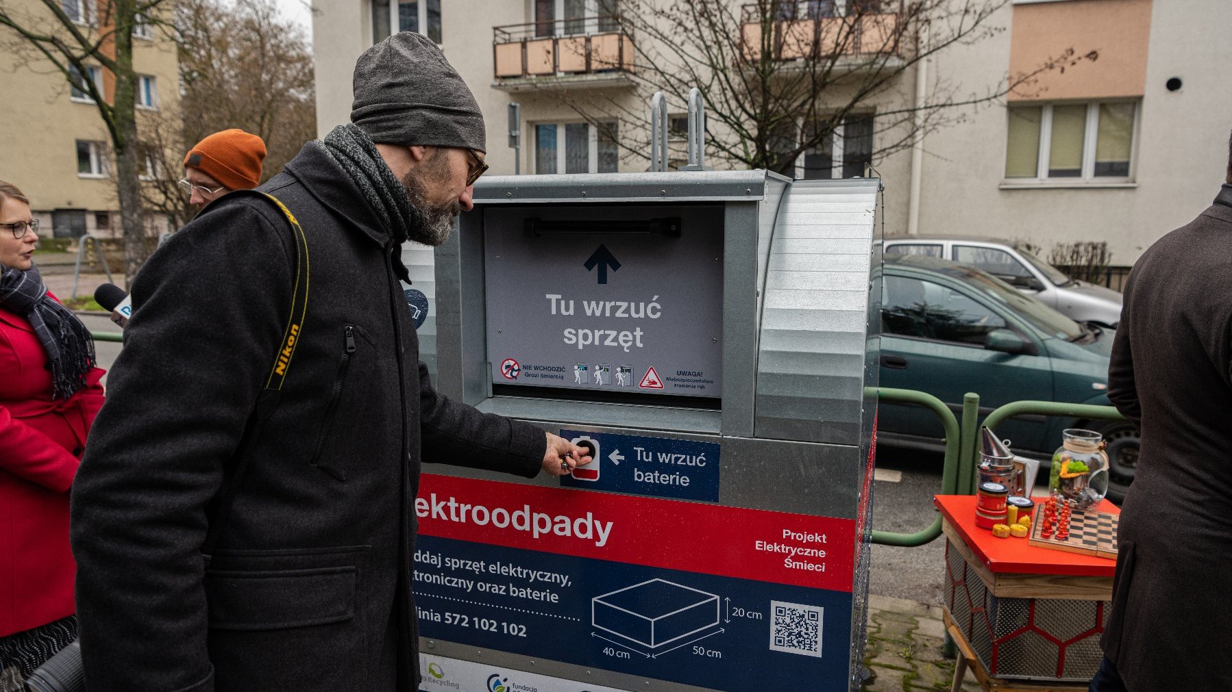 Na zdjęciu mężczyzna wyrzucający baterie do pojemnika