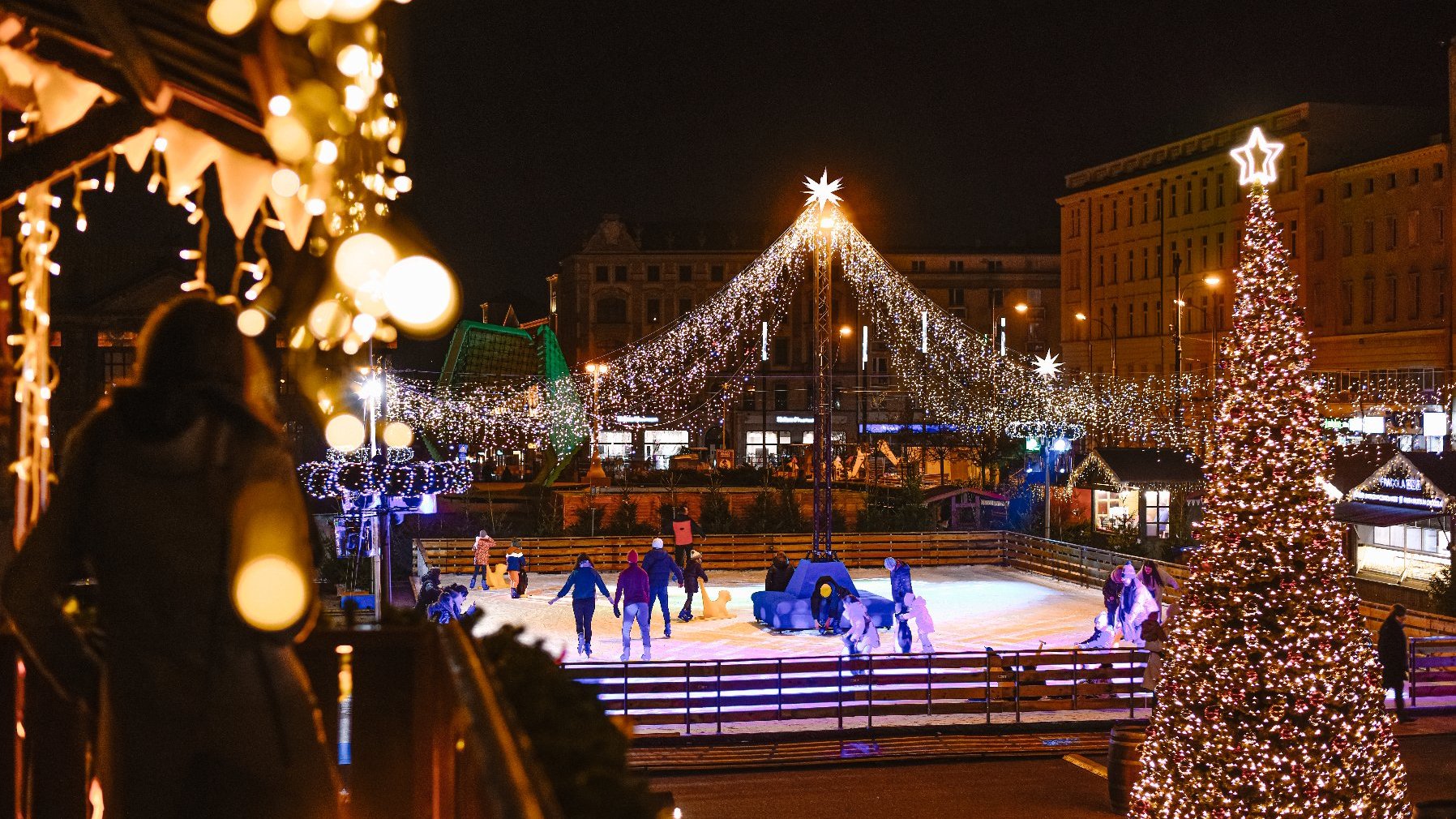 Galeria zdjęć przedstawia lodowisko na placu Wolności i korzystających z niego ludzi.