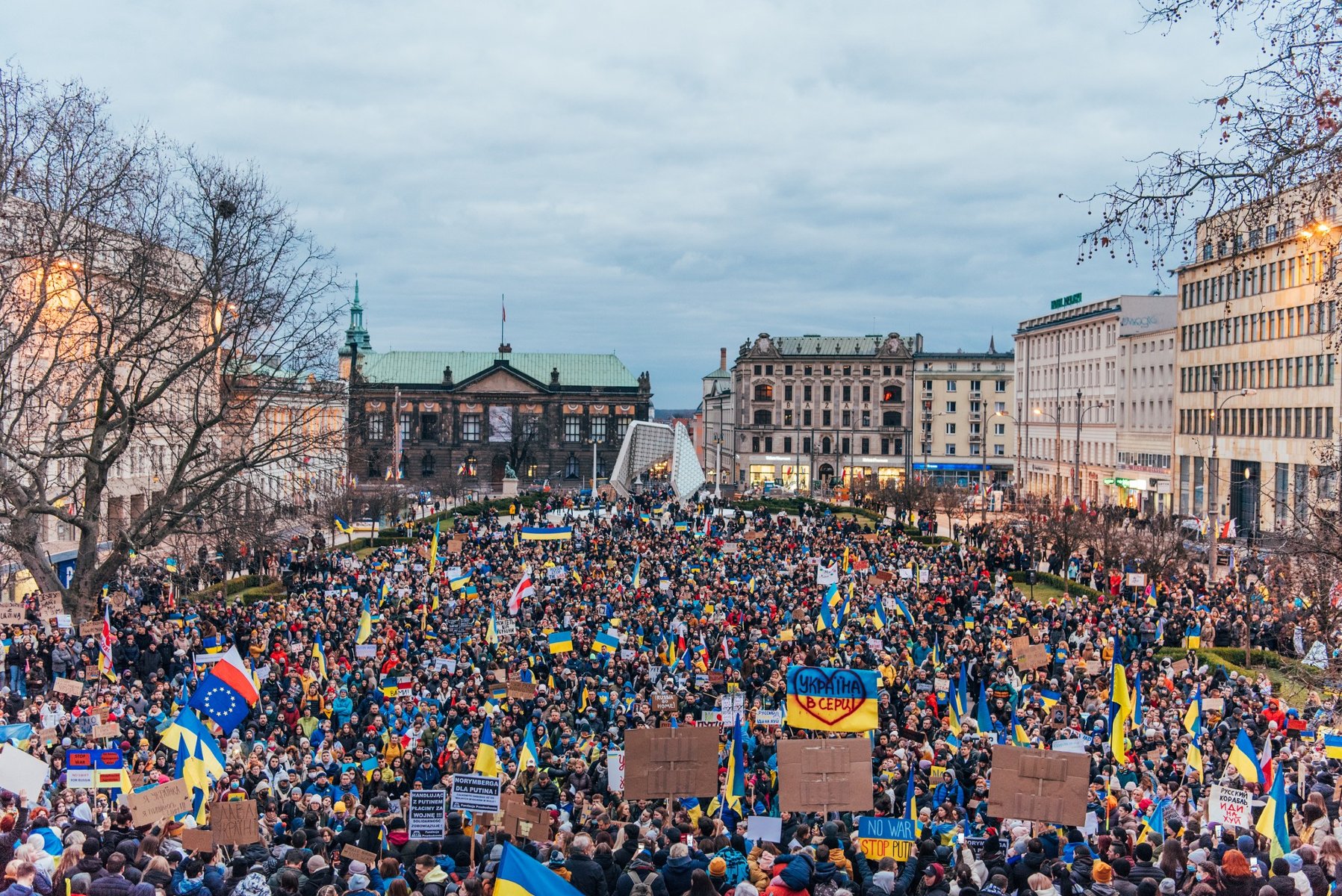 Na zdjęciu tłum ludzi na placu Wolności, protestujących przeciwko wojnie - grafika rozmowy