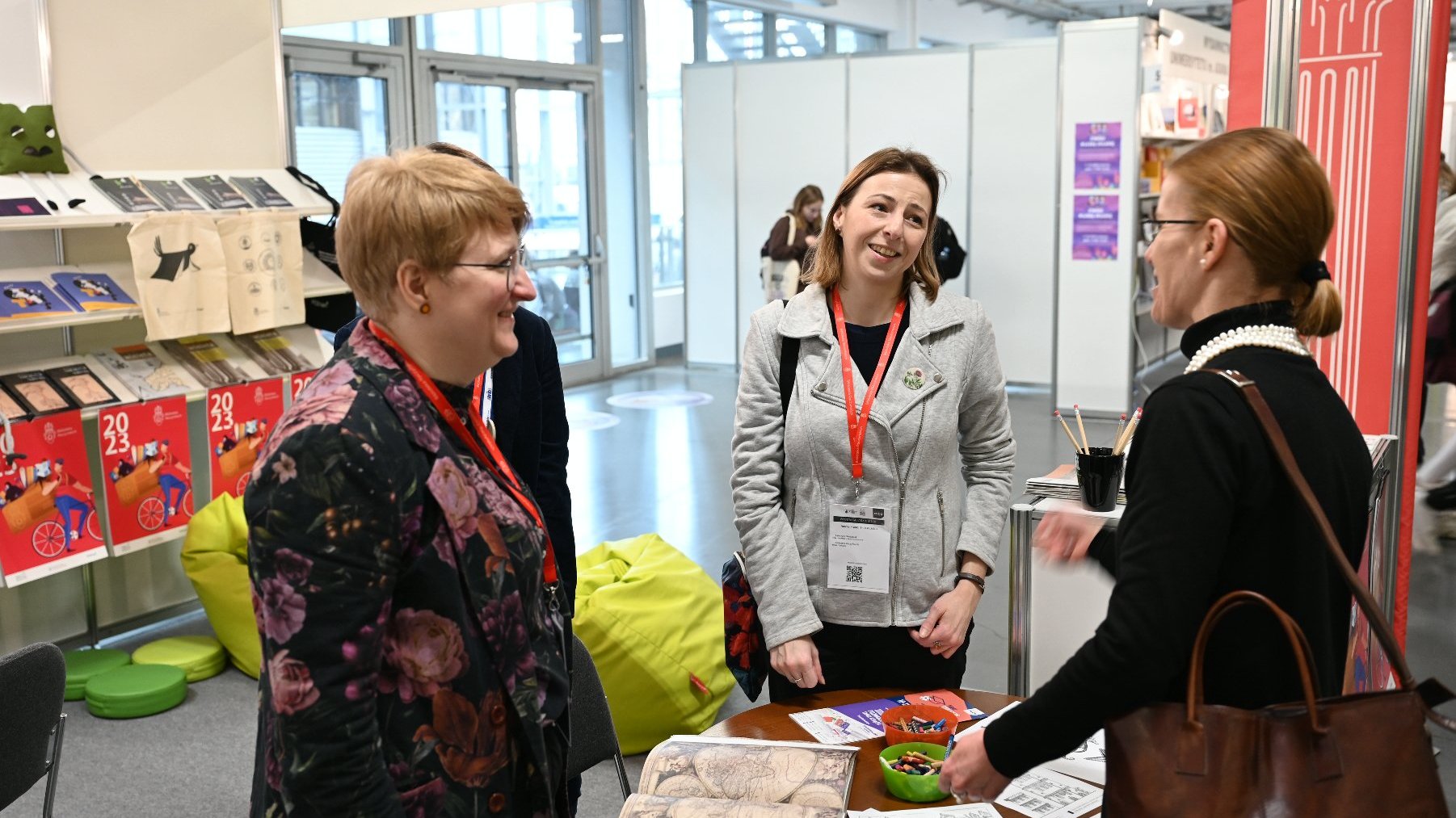 Na zdjęciu trzy kobiety rozmawiające przy stoisku