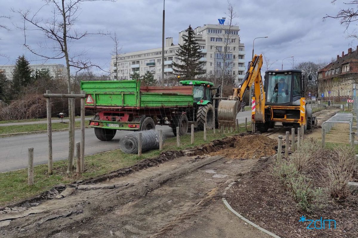 Koparka wybierająca ziemię pod chodnik z nawierzchni mineralnej - grafika rozmowy