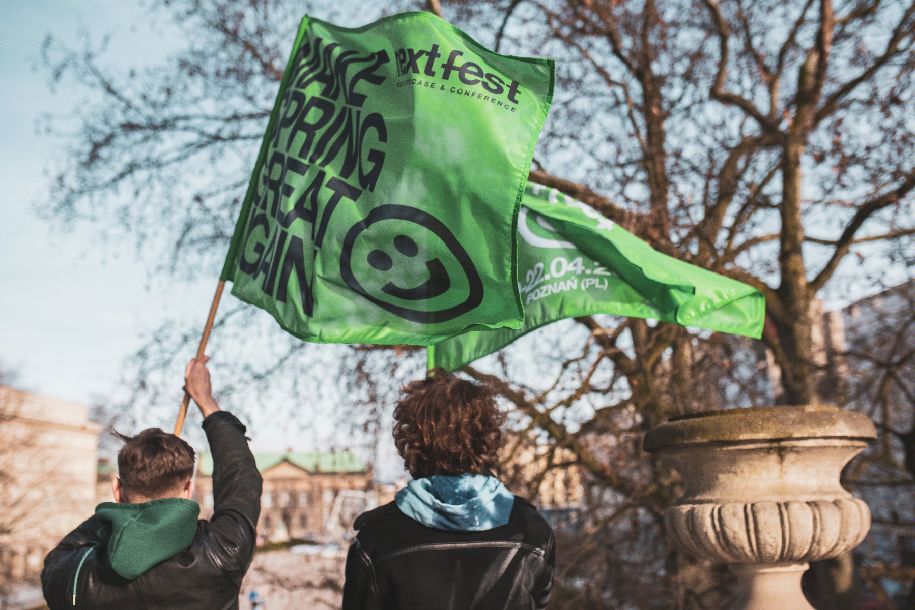 Zielone flagi Next Fest powiewające na balkonie Arkadii z widokiem na plac Wolności - grafika rozmowy