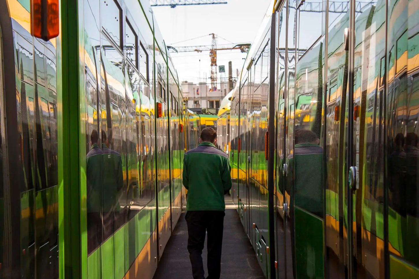 Motorniczy idący pomiędzy dwoma tramwajami - grafika rozmowy