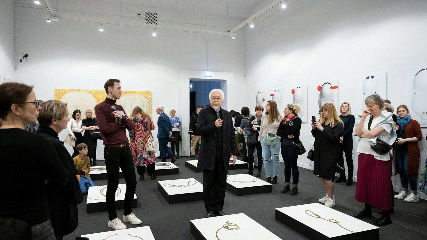 Galeria zdjęć przedstawia grupę ludzi stojąch w przestrzeni wystawienniczej w Muzeum Narodowym w Poznaniu.