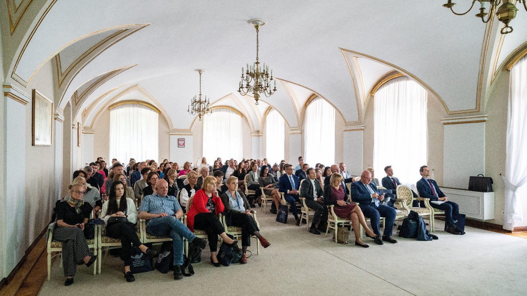 na zdjęciu sala biała urzędu miasta, w niej siedzą słuchacze kondferencji