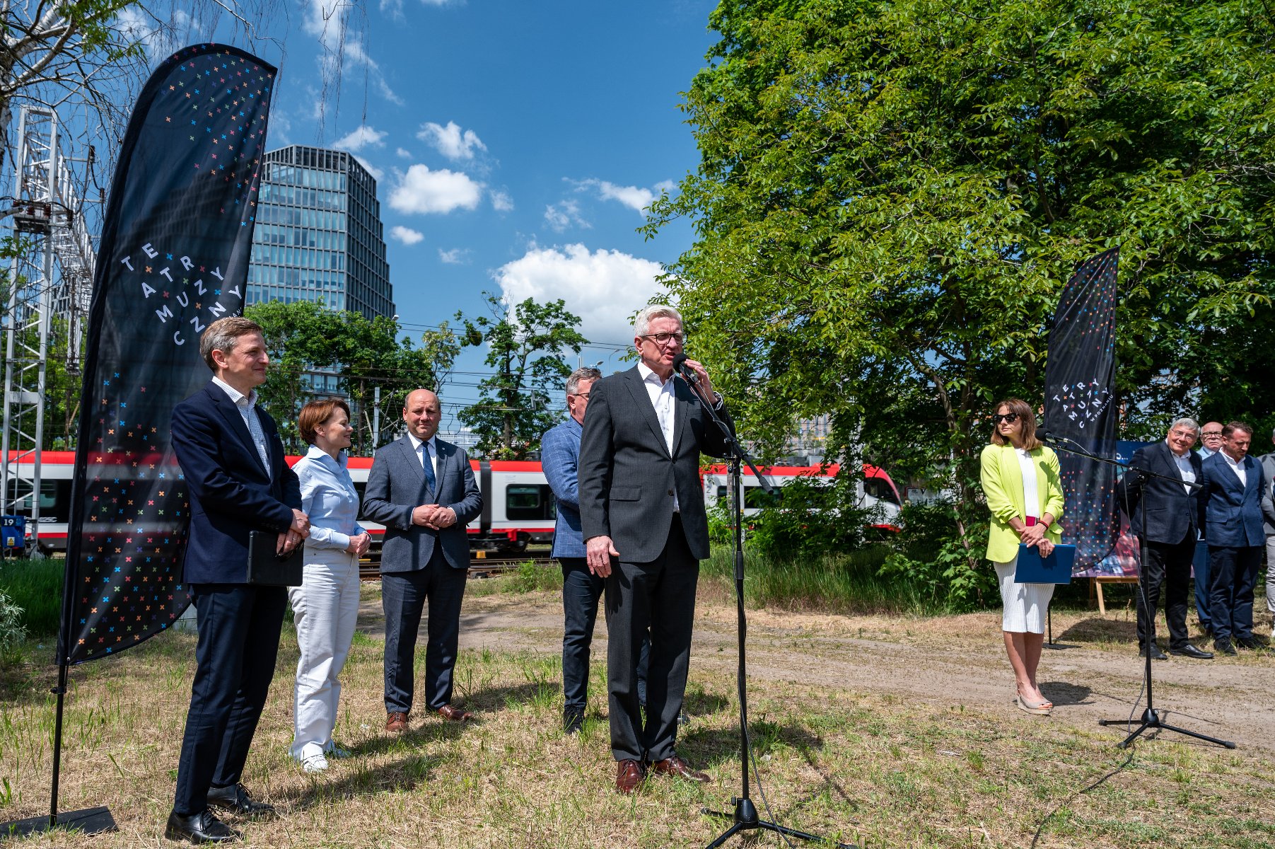 Zdjęcie przedstawia grupę osób podczas konferencji prasowej. W tle biurowiec "Bałtyk". - grafika rozmowy