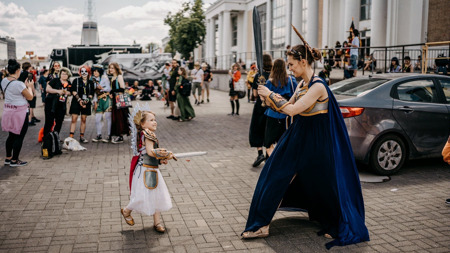 Na pierwszym planie przebrana mama z córką. W tle inni cosplajowcy na terenie MTP