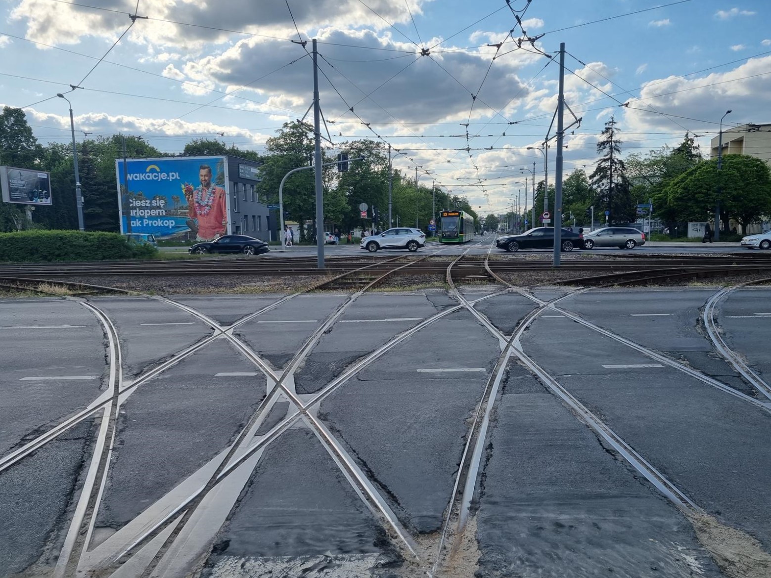 Zniszczone łuki torowiska - widok na strzyżowanie. Na wprost, w tle, tramwaj. - grafika rozmowy