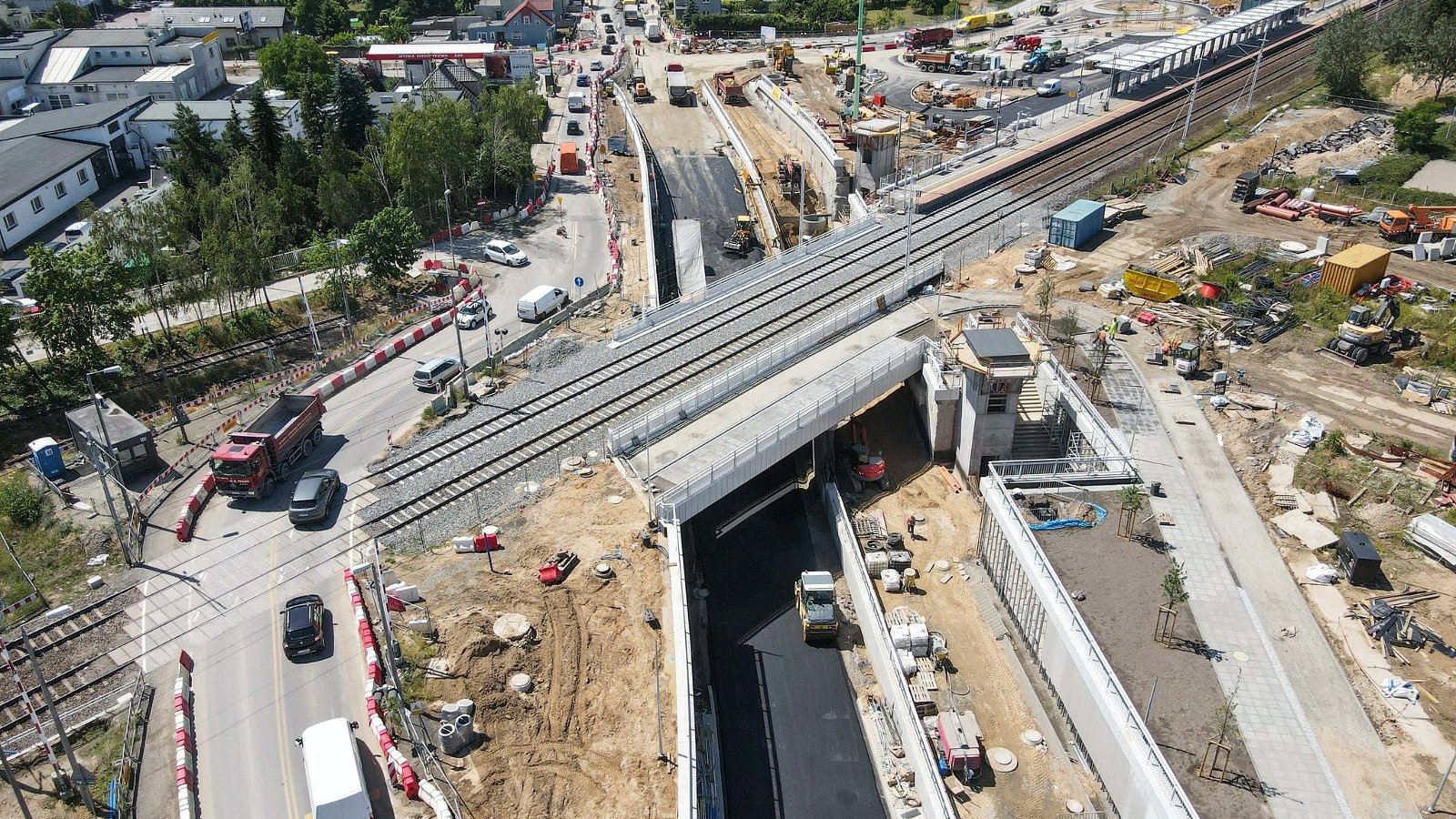 Galeria zdjęć - inwestycja widziana z lotu ptaka, w centrum zdjęć wiadukt, widać maszyny budowlane