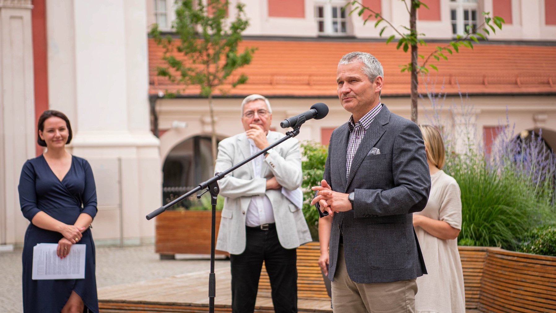 NA zdjęciu uczestnicy konferencji na dziedzińcu urzędu, przy mikrofonie zastępca prezydenta