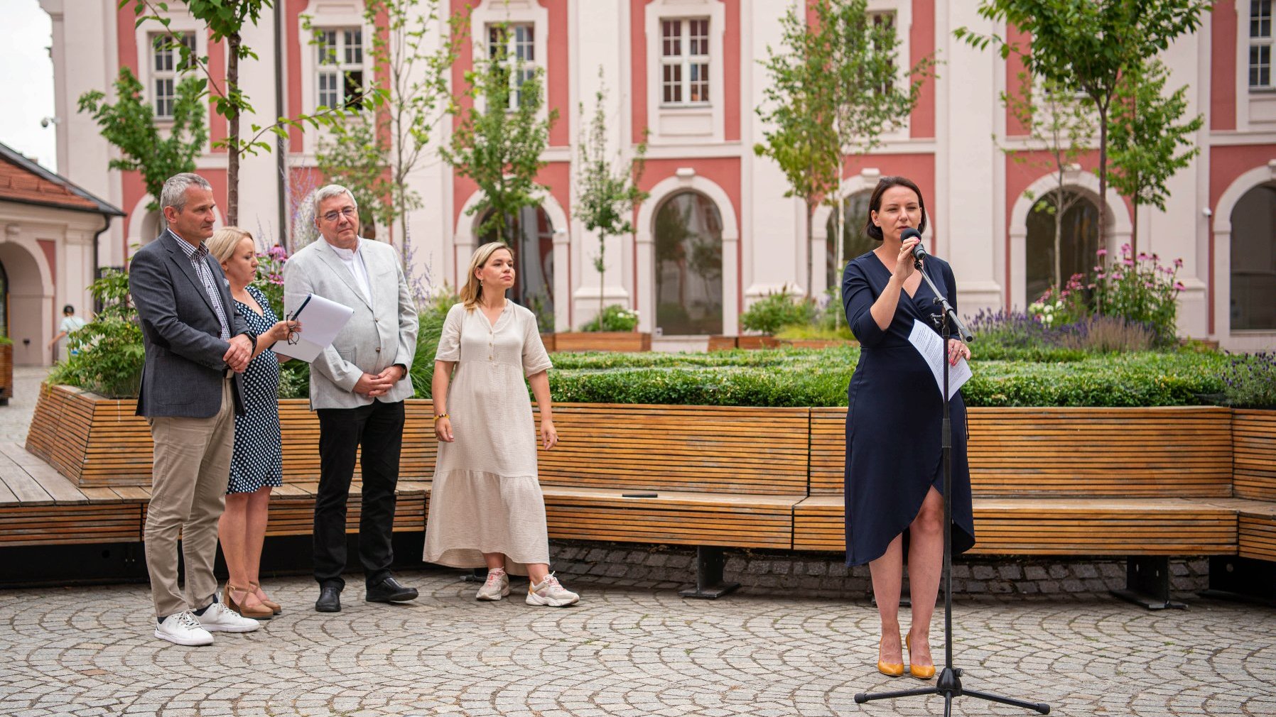 NA zdjęciu uczestnicy konferencji na dziedzińcu urzędu, przy mikrofonie radna Rady Miasta Poznania