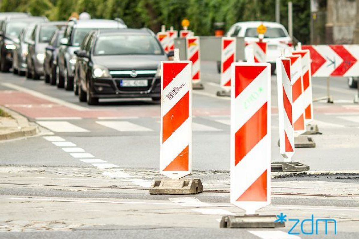 Na zdjęciu zwężenie jezdni, widać oznakowanie, w tle samochody - grafika rozmowy