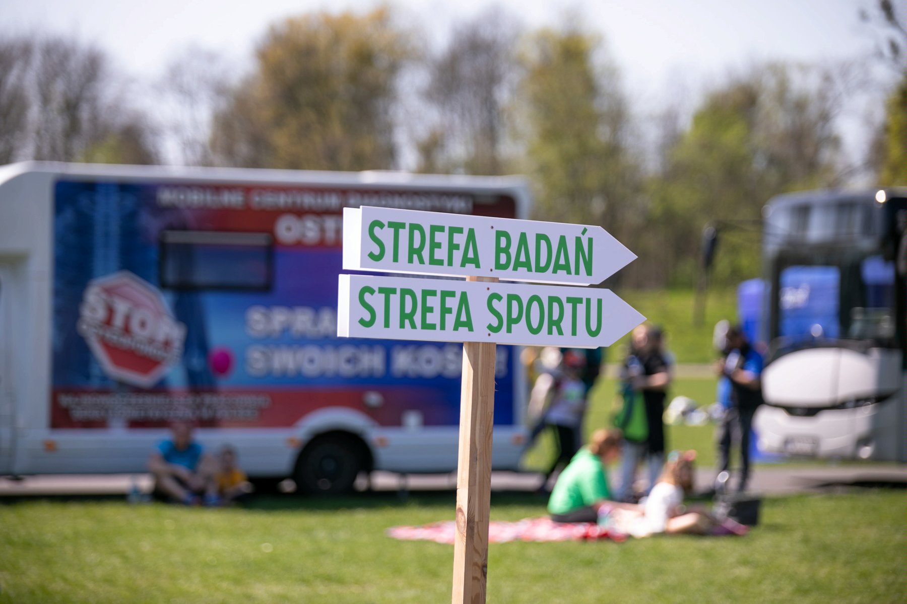 Na zdjęciu drogowskaz z napisem: strefa badań, strefa sportu - grafika rozmowy