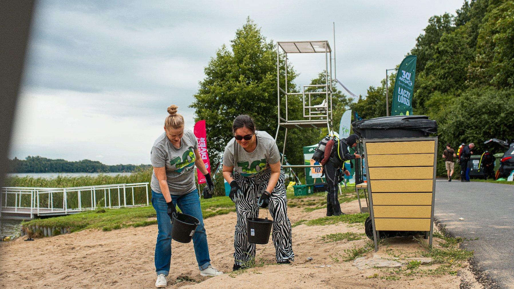 Na zdjęciu dwie kobiety sprzątające plażę kąpieliska