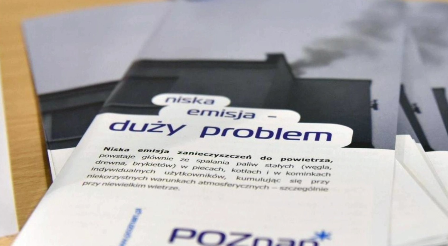 Na zdjęciu ulotki z napisem: niska emisja, duży problem - grafika rozmowy