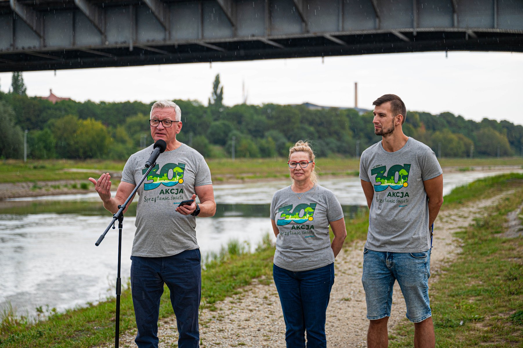 Na zdjęciu konferencja prasowa, przed mikrofonem trzy osoby, prezydent Poznania coś mówi - grafika rozmowy