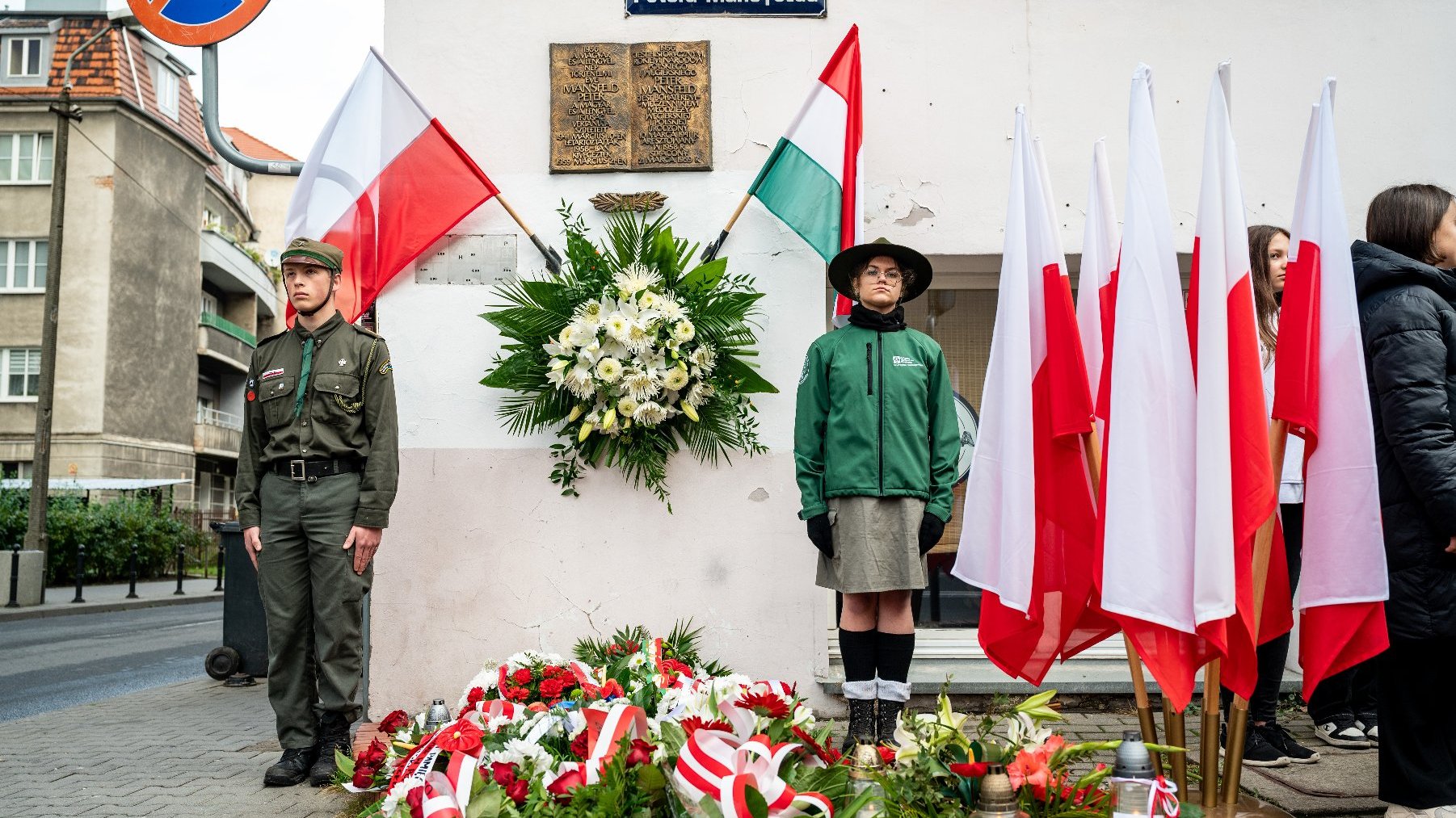 Galeria zdjęć przedstawia obchody rocznicy wybuchu Powstania Węgierskiego, podczas których złożono kwiaty pod tablicami upamiętniającymi Pétera Mansfelda i Romka Strzałkowskiego.