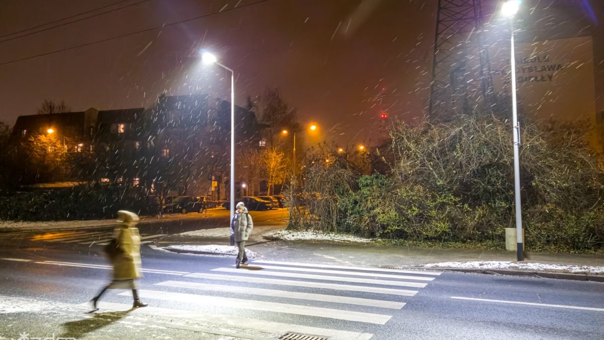 Galeria zdjęć przedstawia oświetlone przejście dla pieszych.