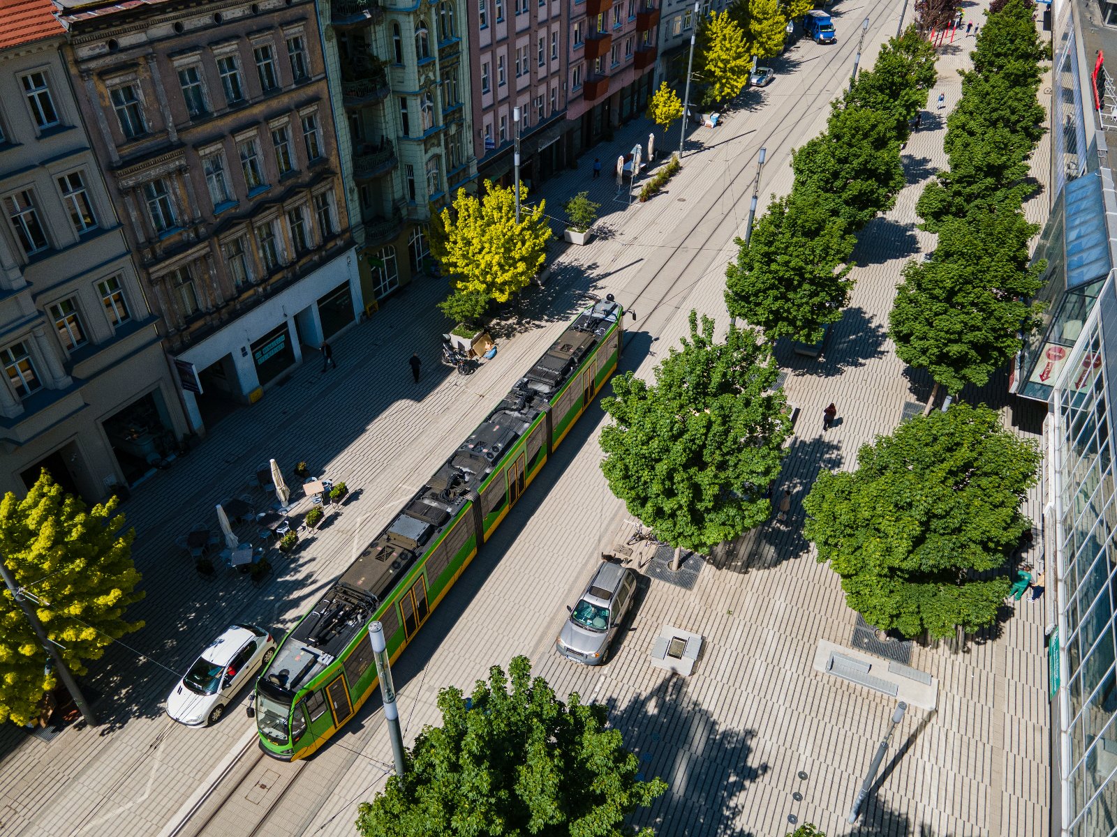 Tramwaj na ul. Św. Marcin pośród zielonych drzew - grafika rozmowy