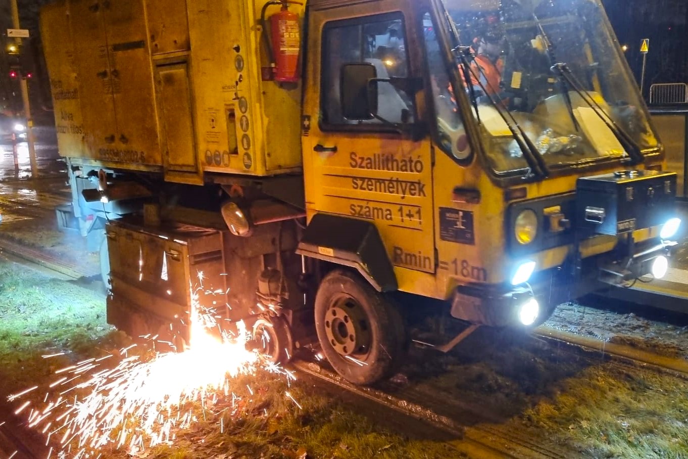 Pojazd na szynach w trakcie szlifowania. Widąć sypiące się iskry. - grafika rozmowy